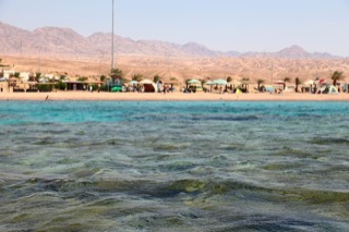 Turquoise Red Sea water off the Aqaba beach, mountains behind